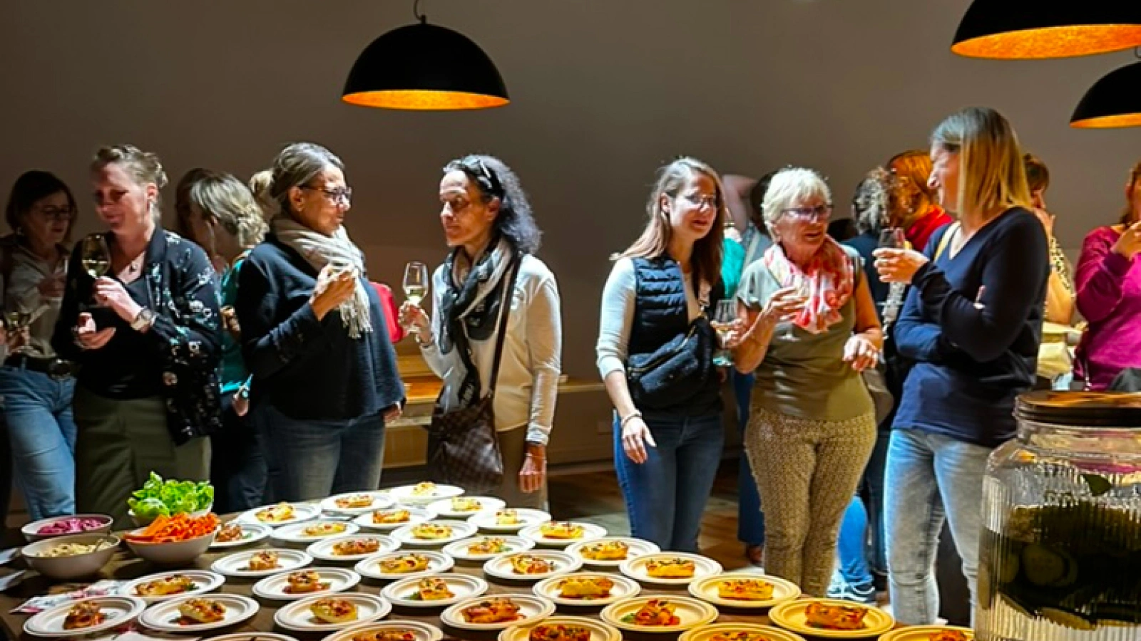 Buffet apéritif dressé pour un séminaire à La Ferme Marie Hélène, avec des invités partageant un moment convivial.