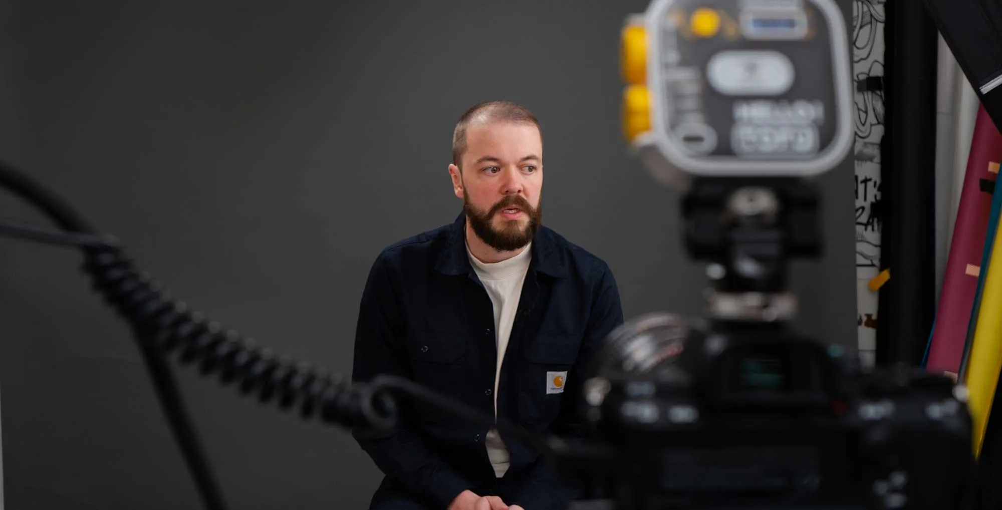 Kris Holland, Kitto's founder sat in a photography studio sat behind a camera.