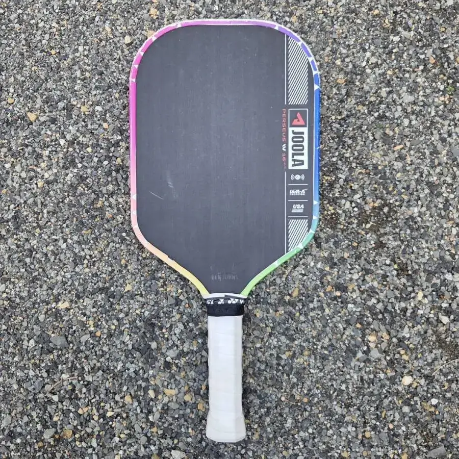 A JOOLA Perseus Pro IV Pickleball Paddle on gravel.