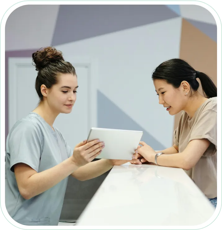 Two young women are looking at a tablet.