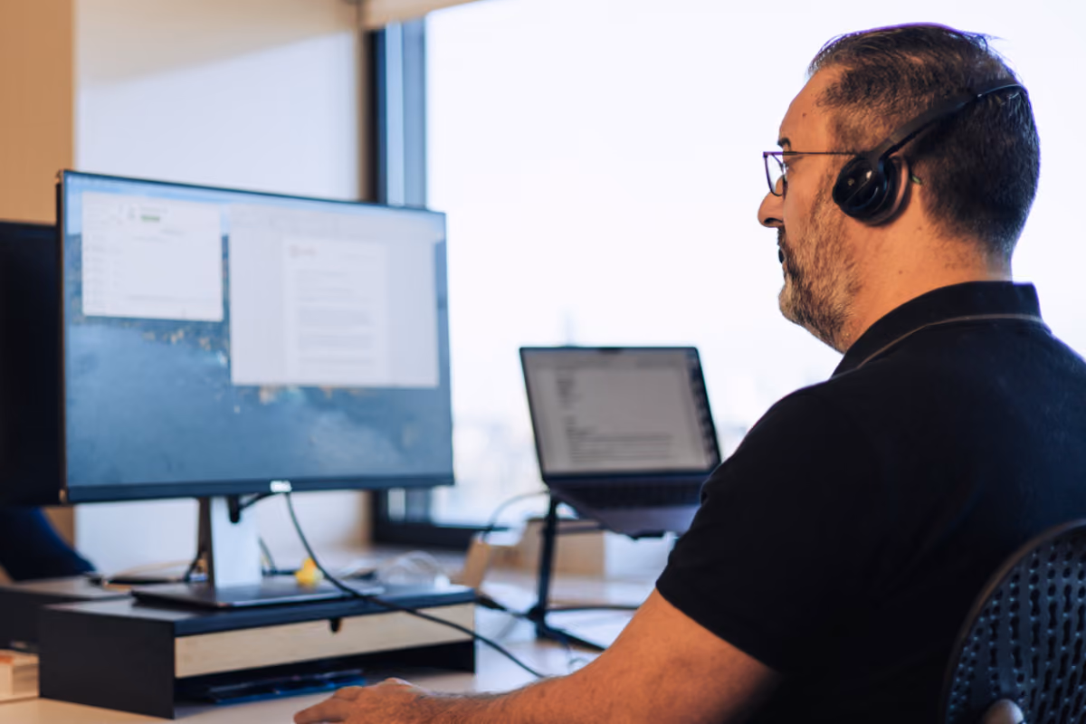 Agent wearing a headset at a dual-monitor desk, photographed by Digitalmakers
