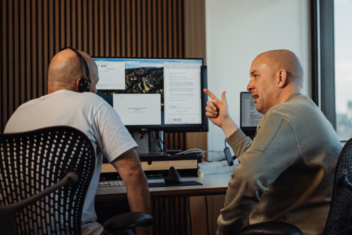 Two colleagues at a monitor desk, photographed by Digitalmakers