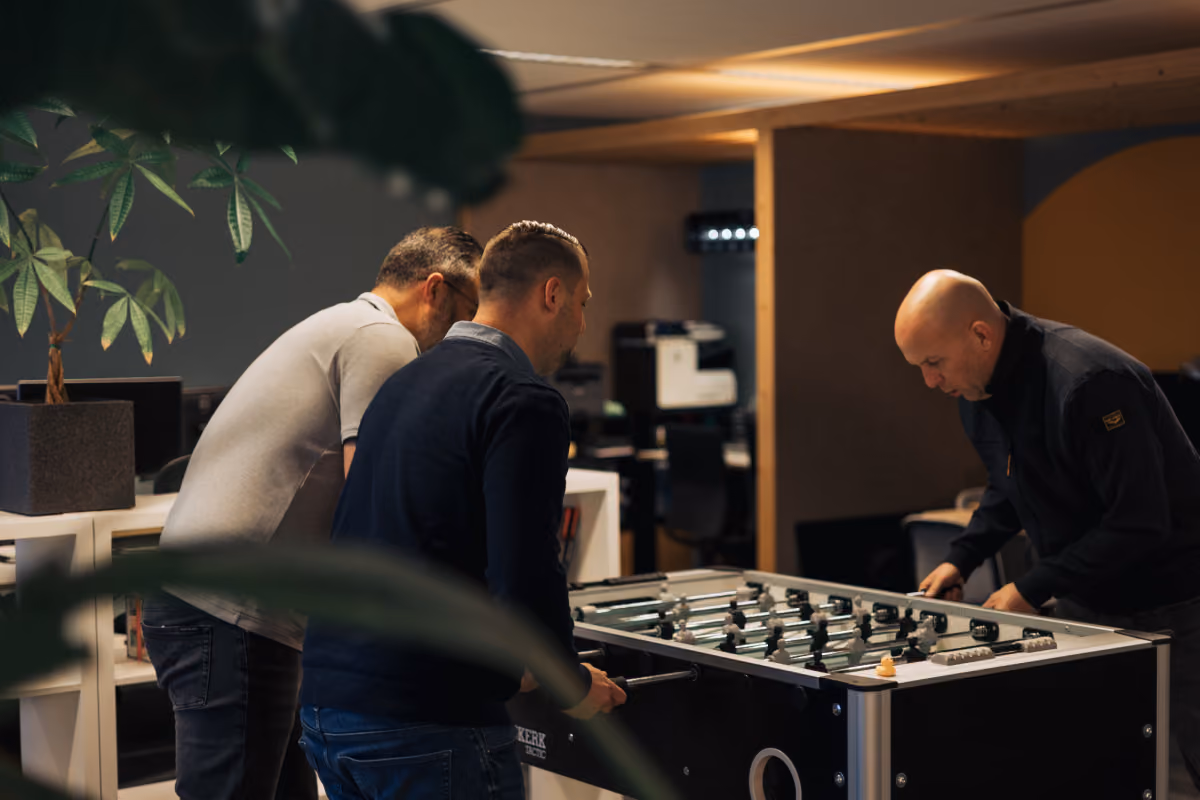 Colleagues playing table football in an office, photographed by Digitalmakers
