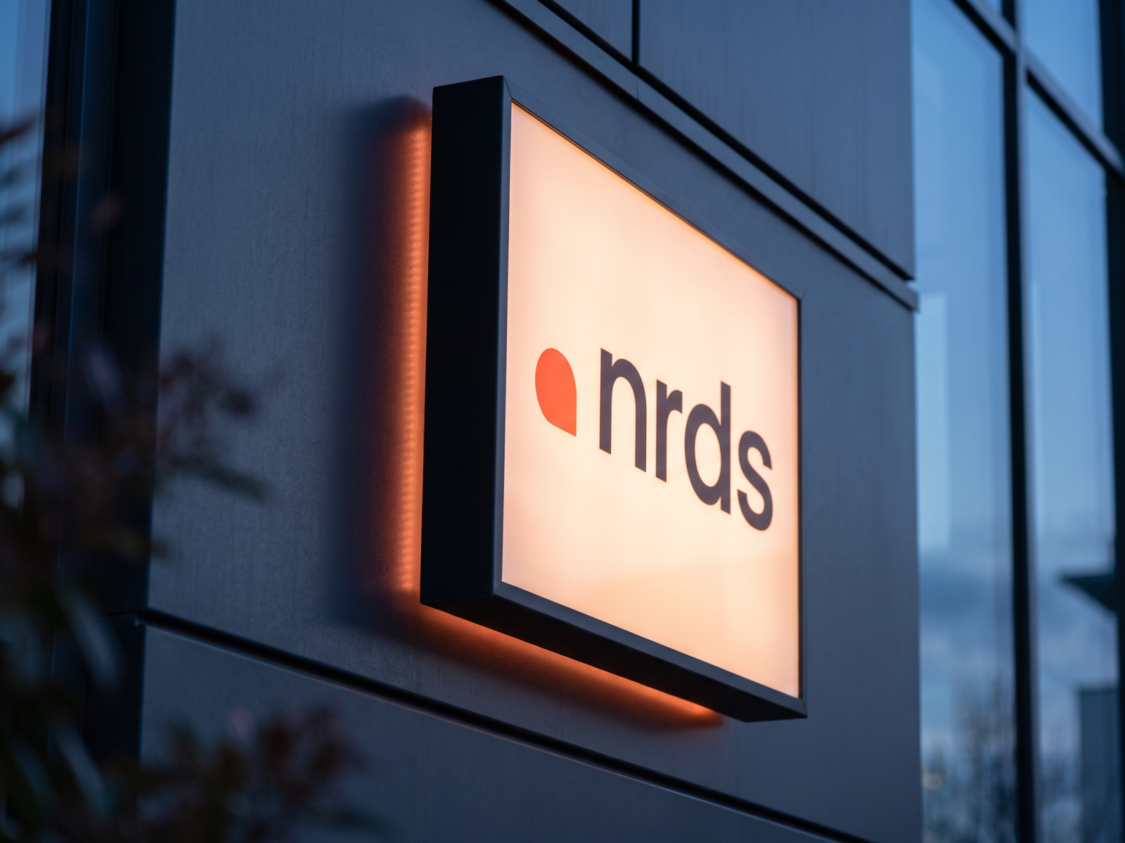 nrds brand identity by Digitalmakers on an illuminated office sign at dusk
