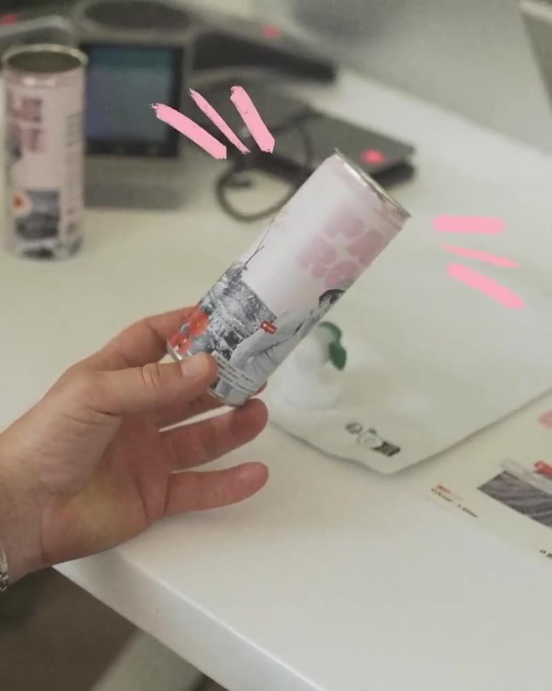 A hand turns the printed Bowi can above the design table
