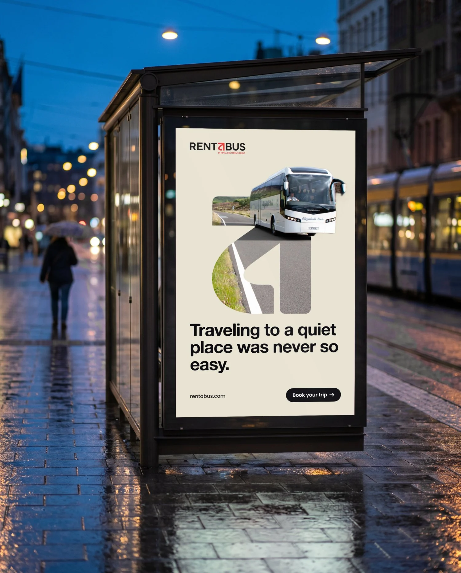 The same bus shelter with a sand coloured poster: a coach drives out of a letter filled with a country road, above the line Traveling to a quiet place was never so easy.