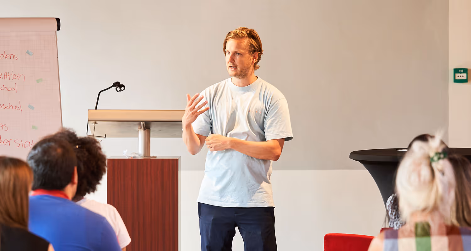 Een trainer geeft voor een groep deelnemers een presentatie