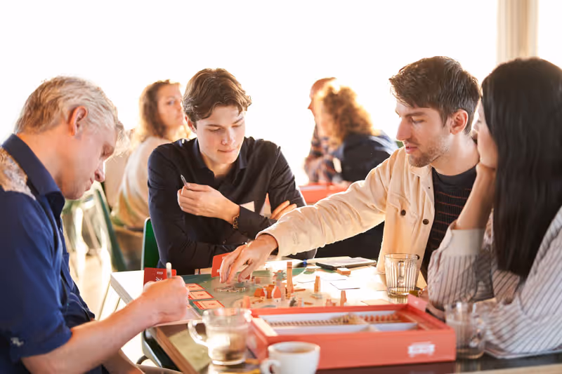 Deelnemer die een spel speelt aan tafel met andere deelnemers