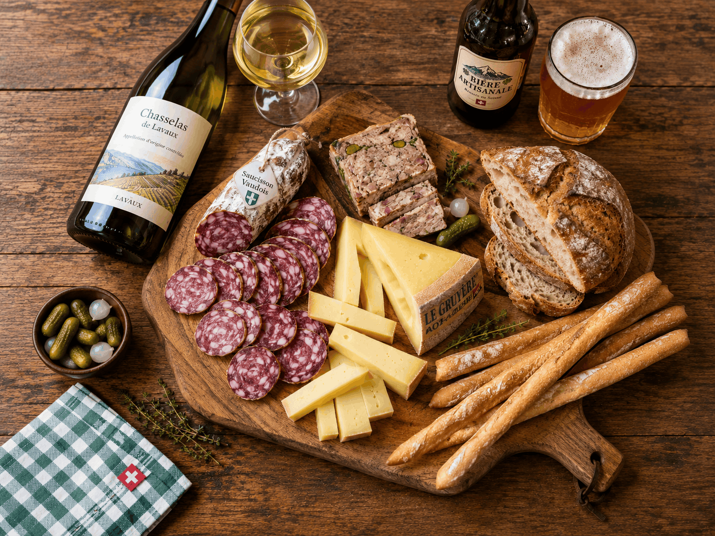 Composition gourmande vue de dessus sur une planche en bois : tranches de saucisson vaudois, morceaux de Gruyère AOP, terrine, pain et flûtes, une bouteille de Chasselas de Lavaux et une bière artisanale, avec un cadenas ouvert et une carte d'énigme glissés entre les produits. Tons chauds, ambiance terroir.