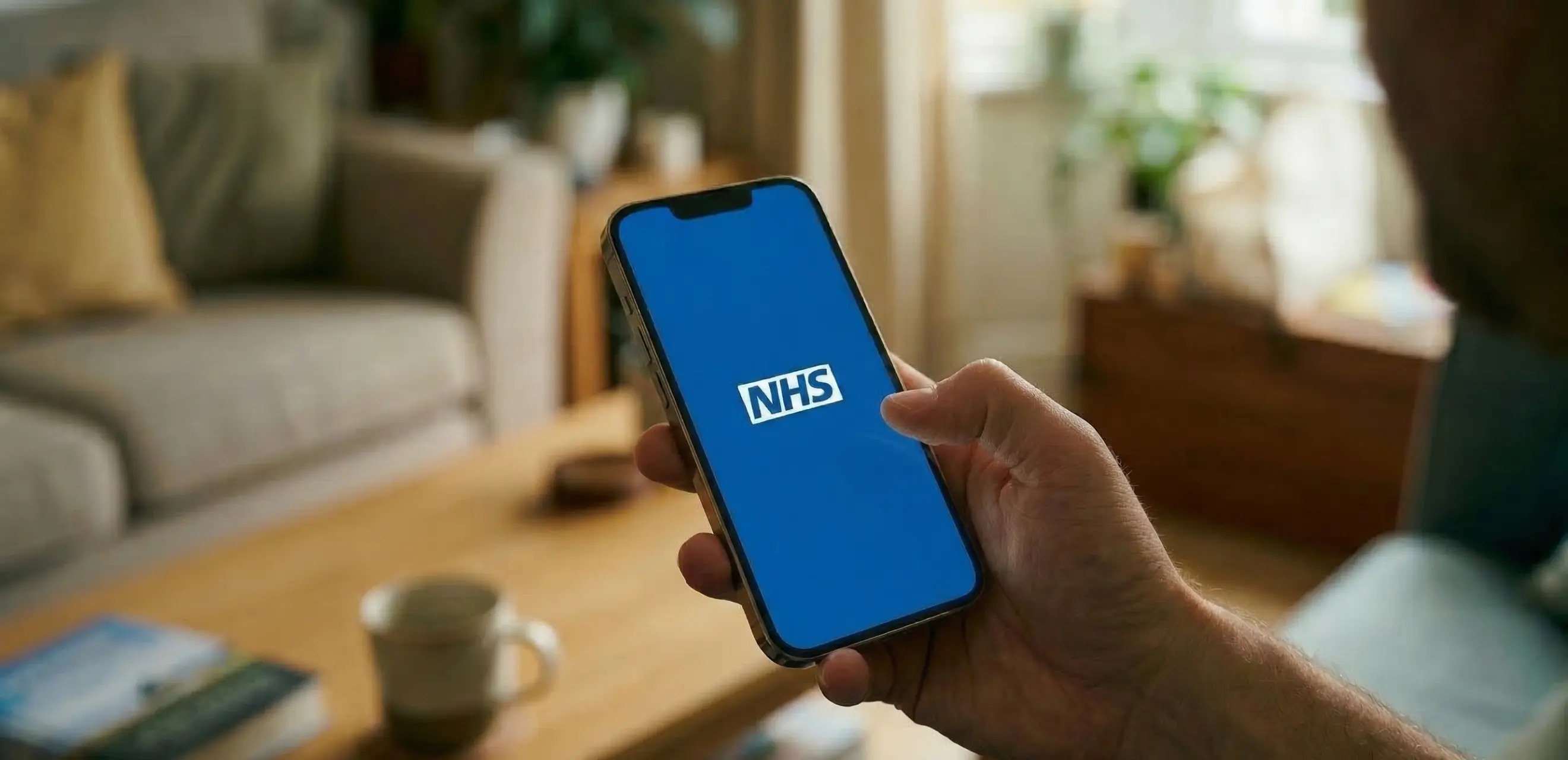 Person holding phone with NHS app open