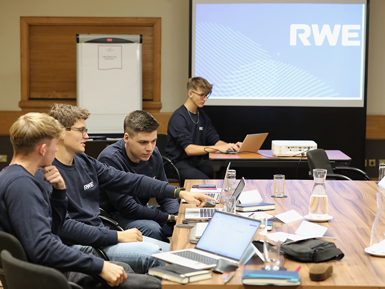 A grou pf young RWE workers using laptops in the RWE office. 
