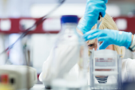 UCL student using pipette in a lab.