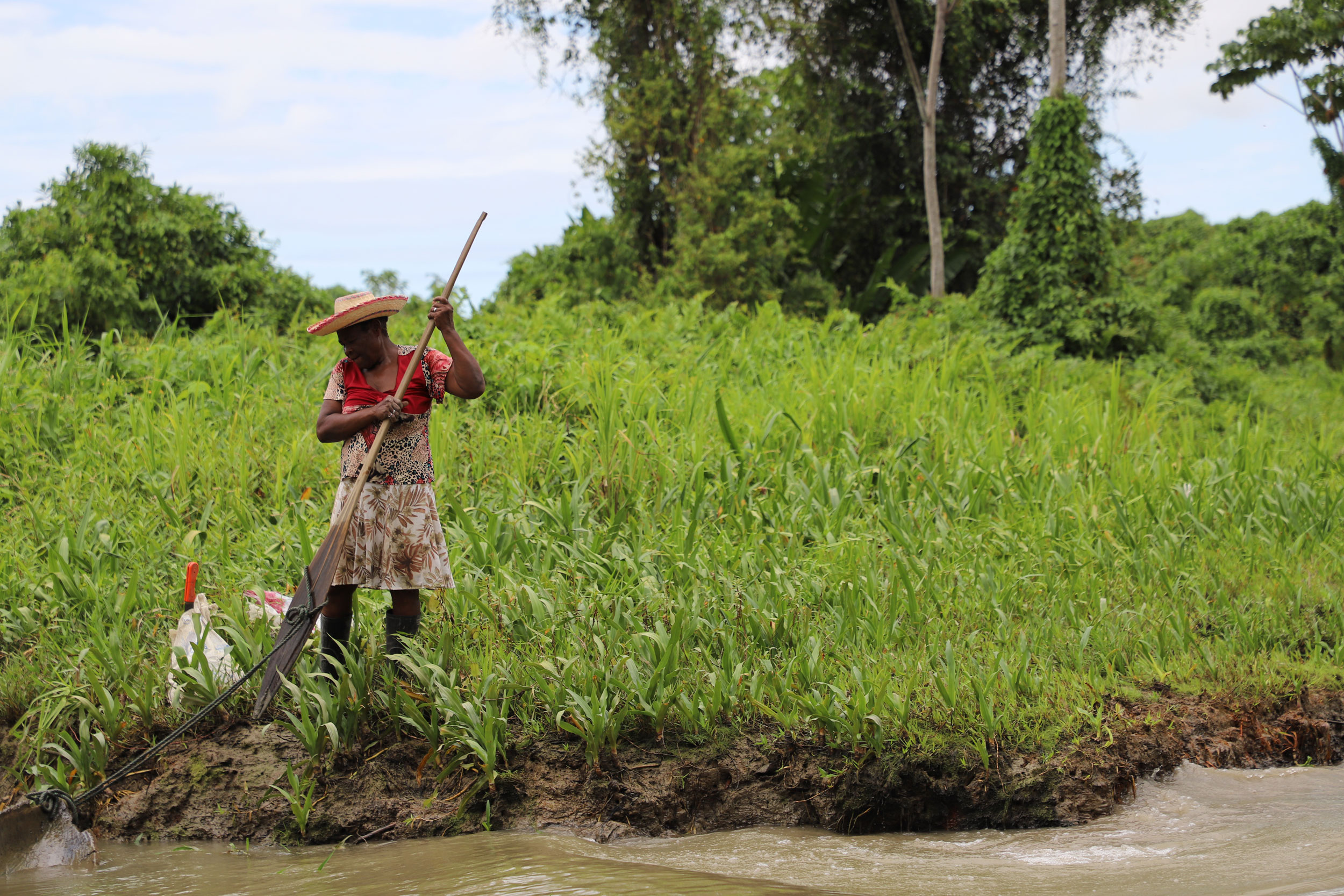 An Afro-descendant woman in Colombia farms by a riverside