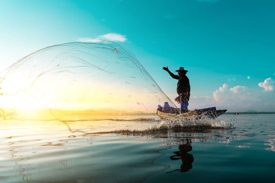 A fisherman launches a net at dawn in the Philippines