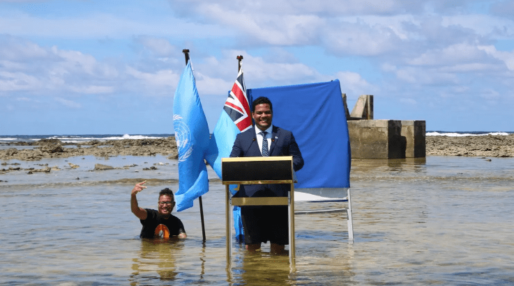 Tuvalu’s Minister for Justice, Communication, and Foreign Affairs, Simon Kofe, gives a COP26 statement while standing in the ocean in Funafuti, Tuvalu, on November 5, 2021.