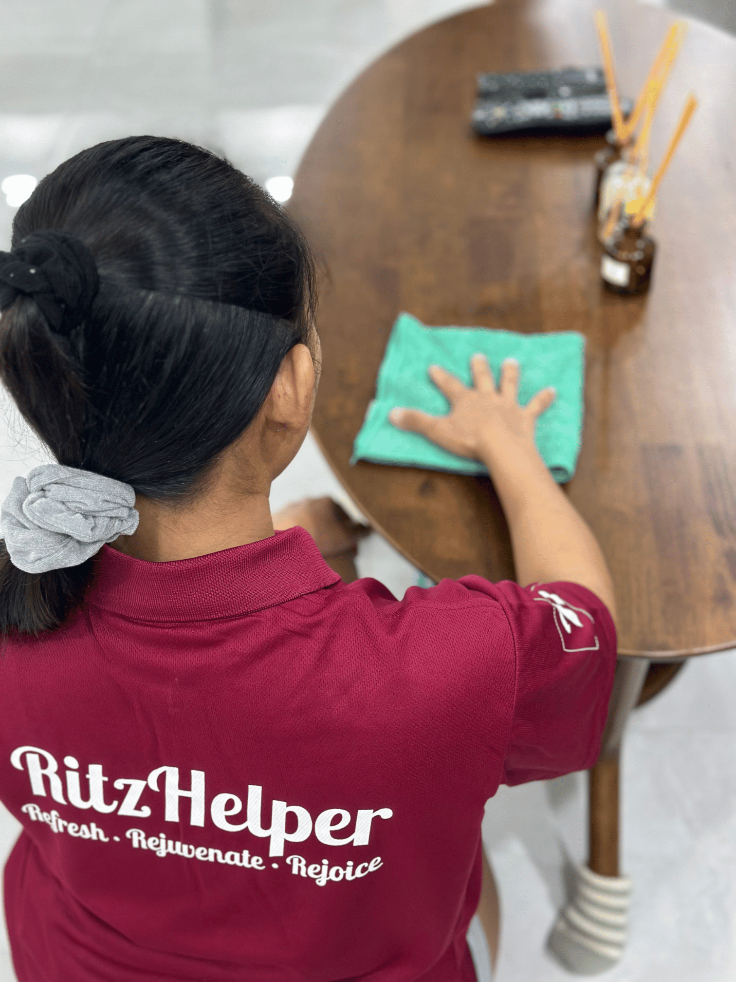 RitzHelper cleaner wiping a dining table in a bright Punggol home