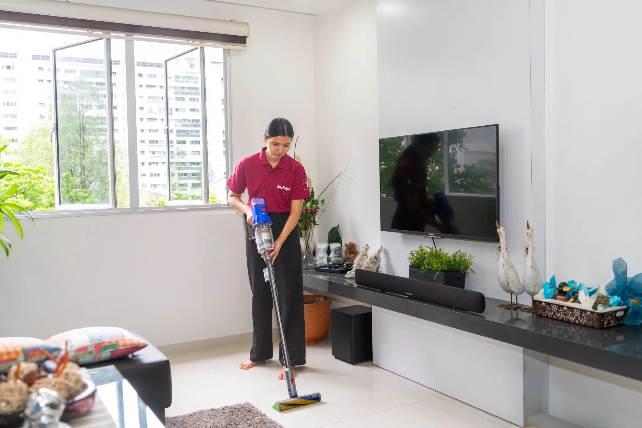 RitzHelper cleaner vacuuming a living room in a Singapore home