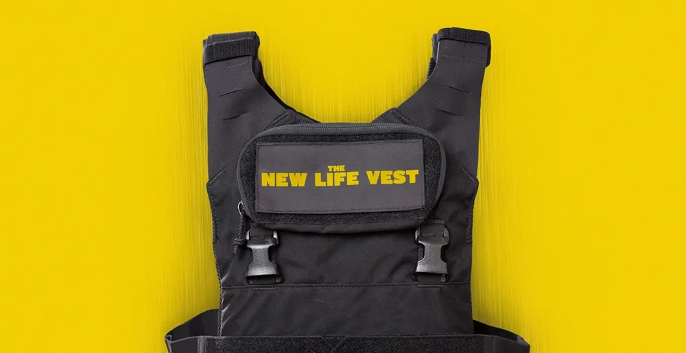 Black tactical vest with yellow text label reading 'The New Life Vest' on a bright yellow background.
