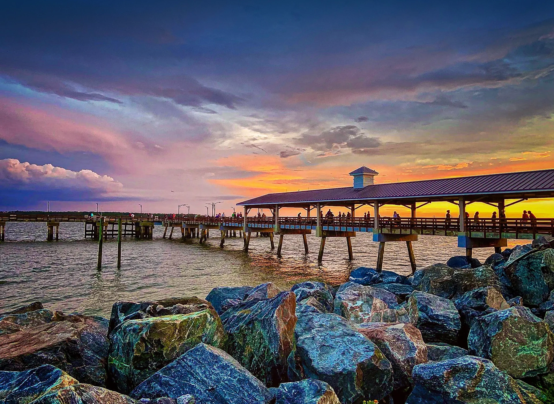 A scenic pier extending over the water at sunset