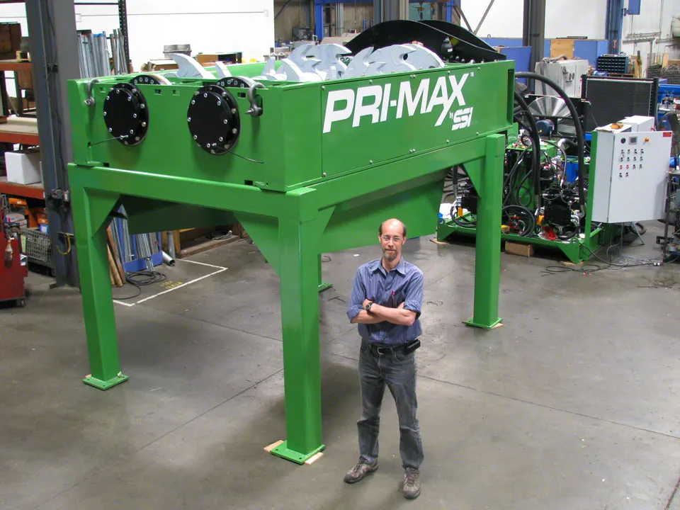 A man standing in front of a green machine.