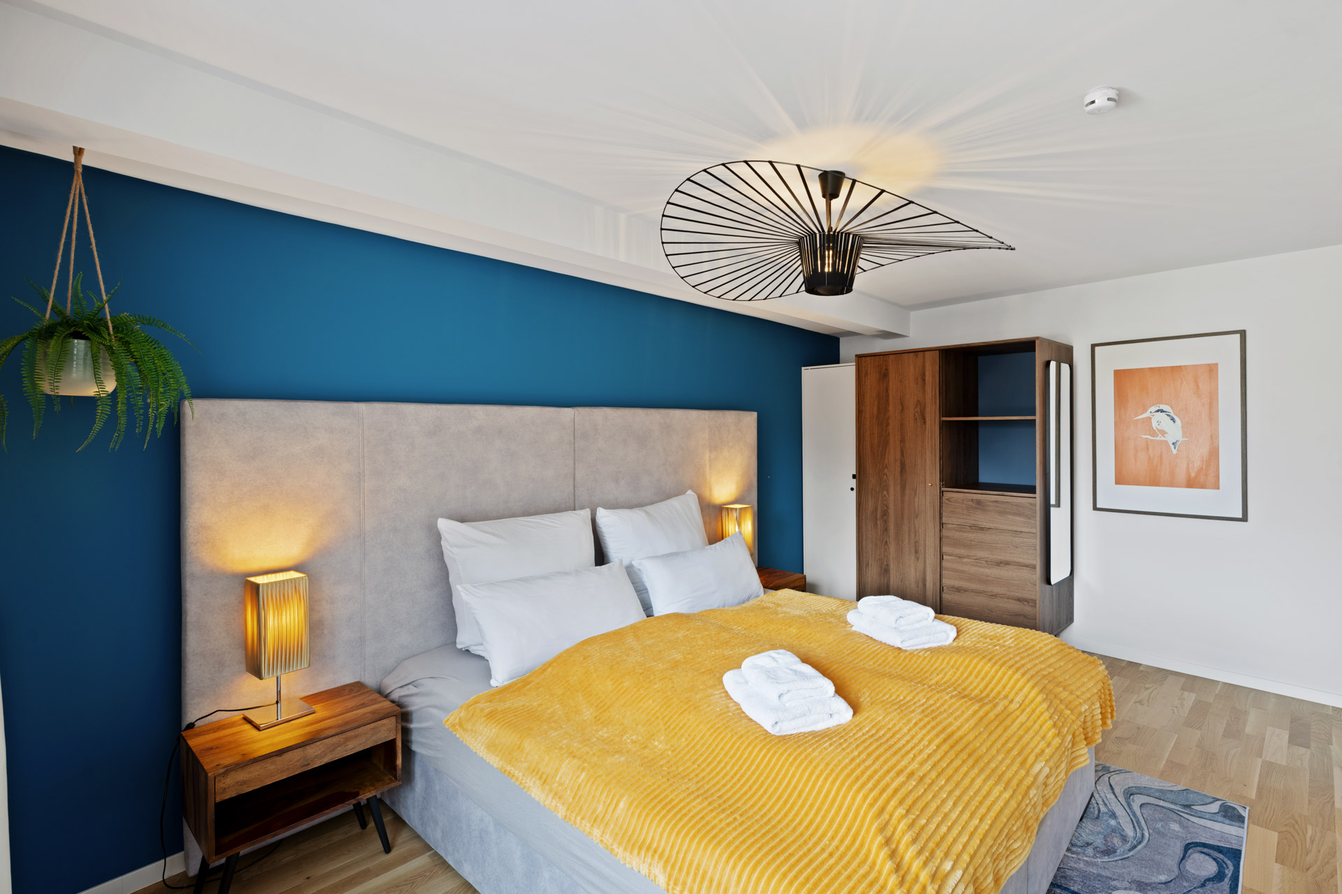 Boxspringbett der Ferienwohnung Eisvogel vor blauer Akzentwand