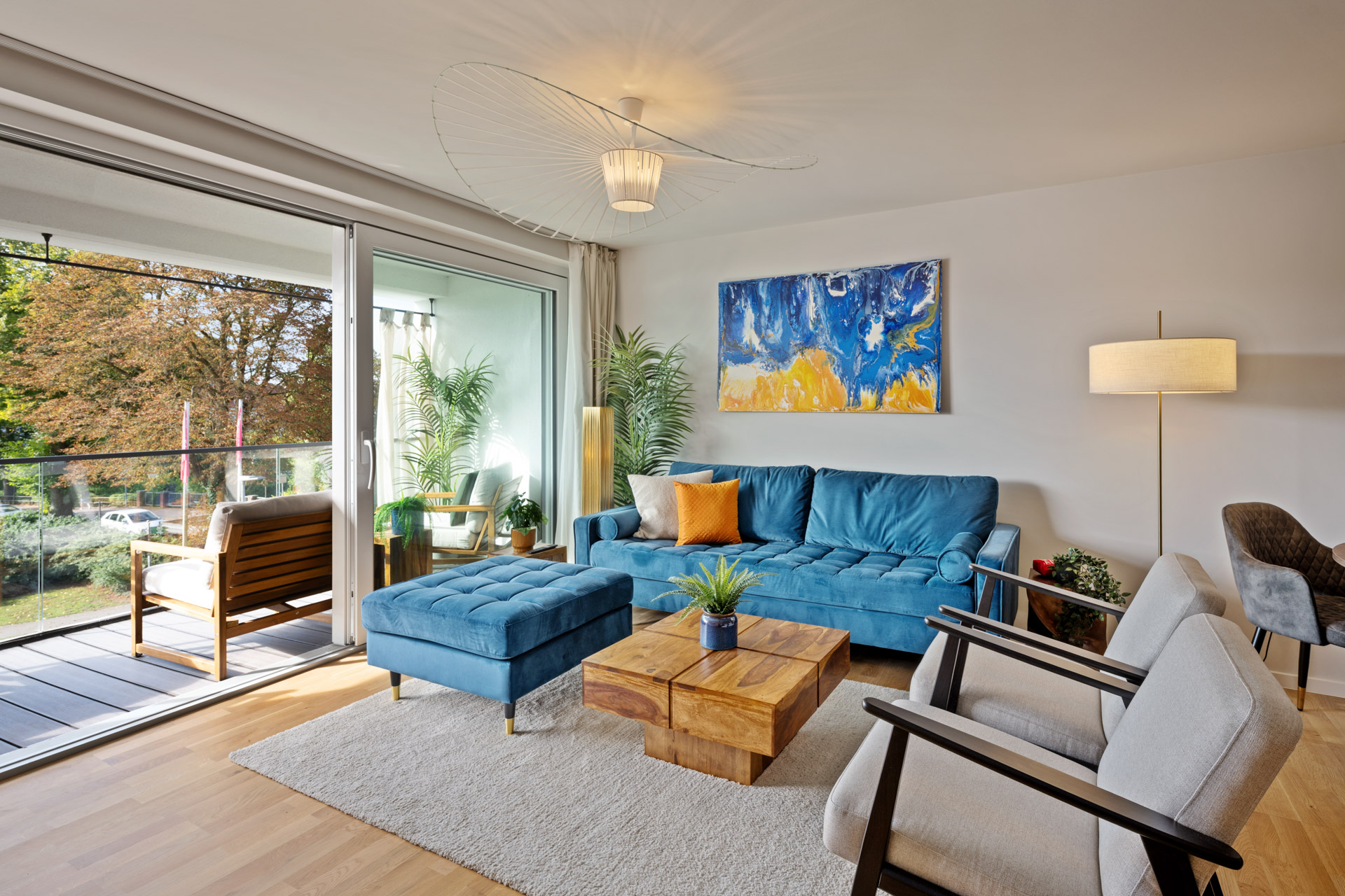 Wohnbereich der Ferienwohnung Eisvogel mit blauem Sofa und Balkonzugang