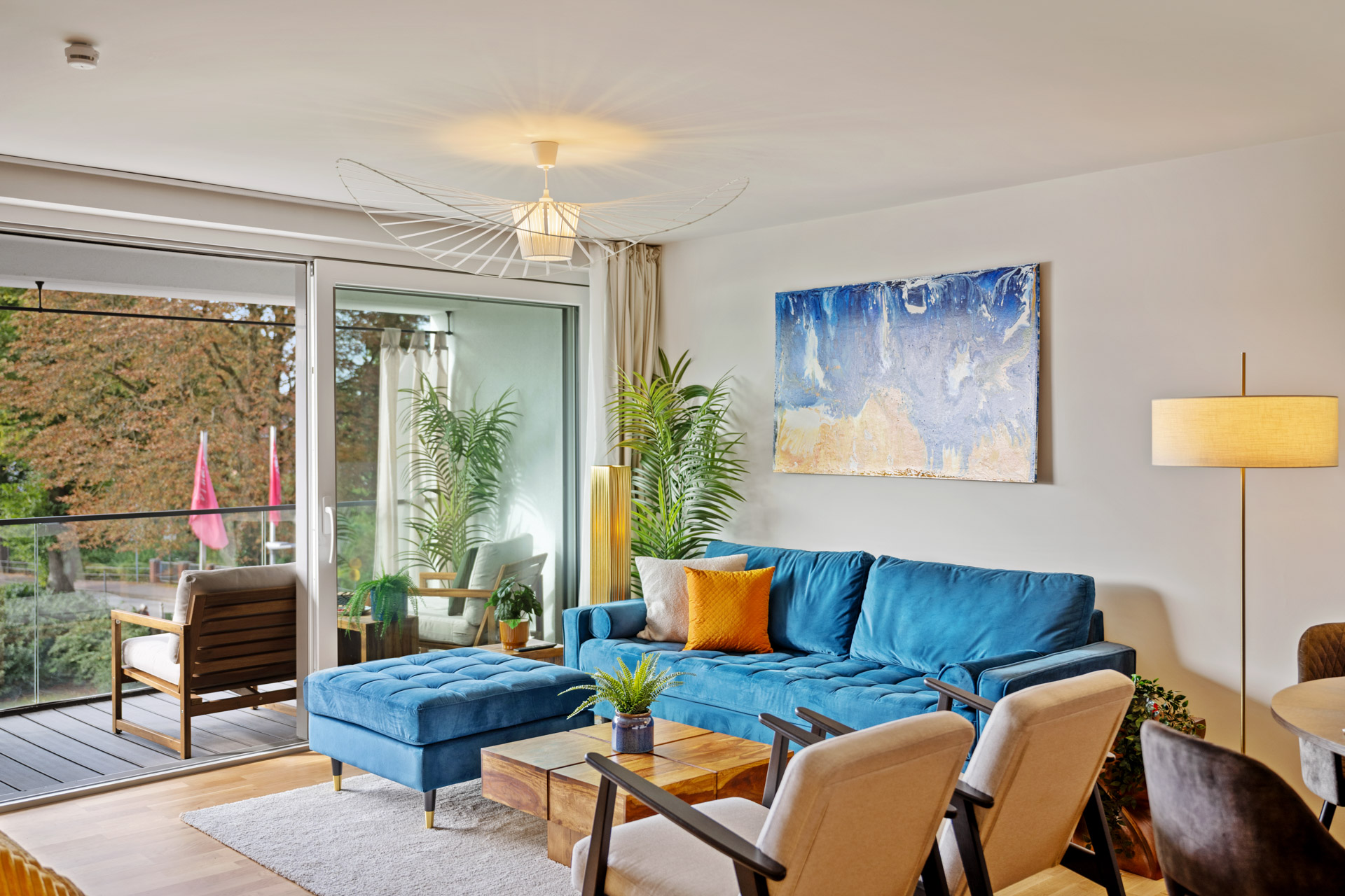 Wohnbereich der Ferienwohnung Eisvogel mit blauem Sofa und großem Fenster