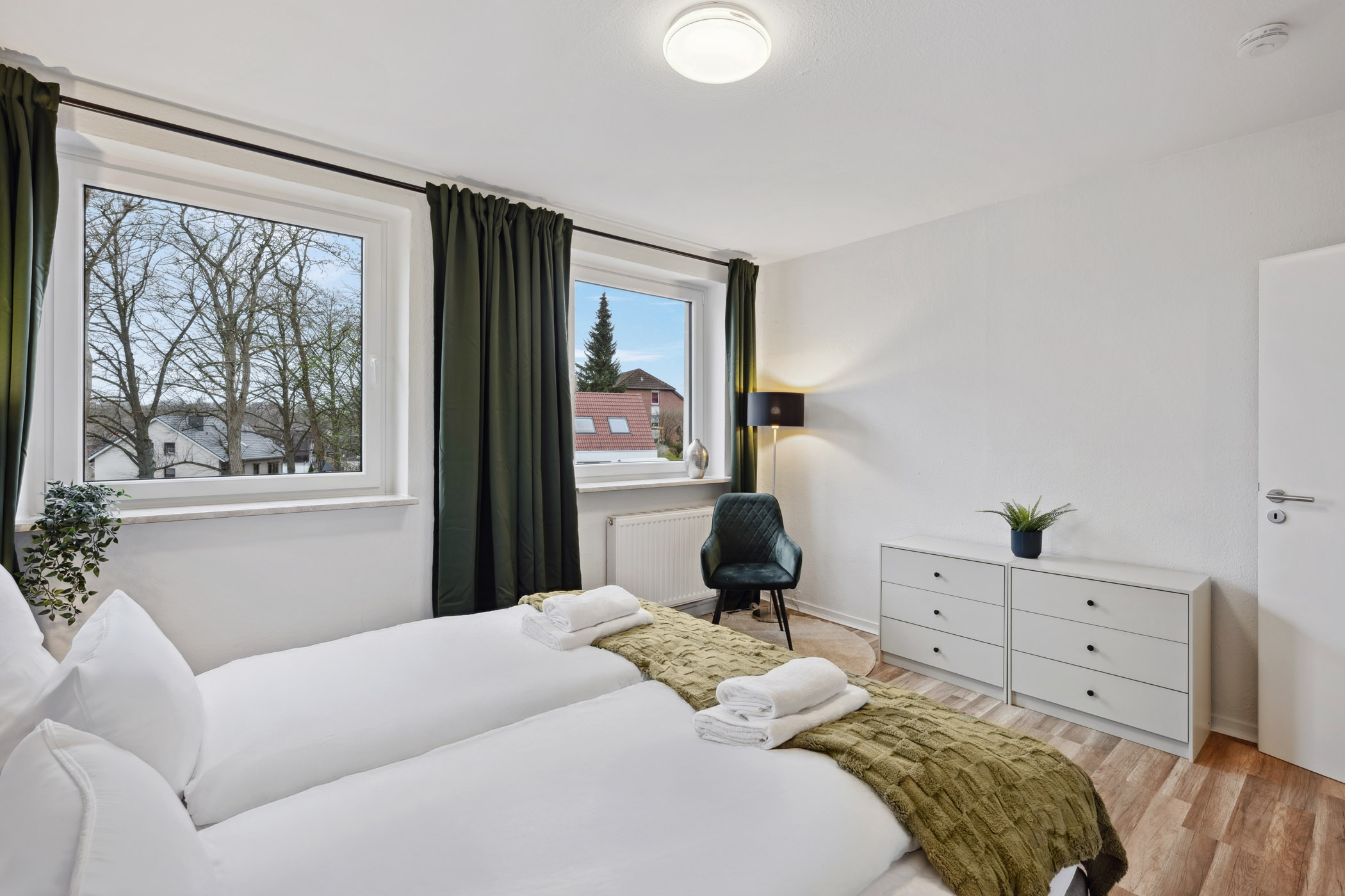Schlafzimmer der Ferienwohnung Sperling mit Doppelbett und zwei Fenstern