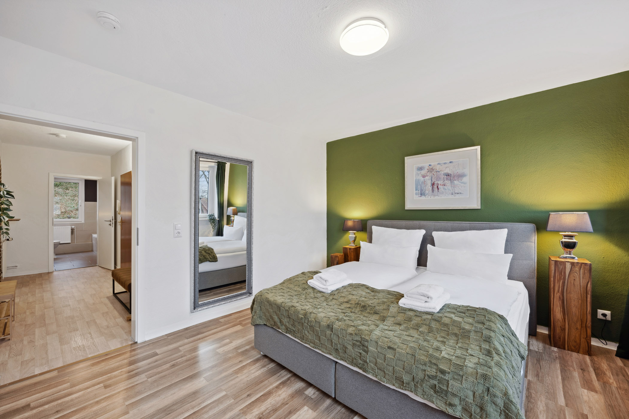 Schlafzimmer der Ferienwohnung Sperling mit Doppelbett, Spiegel und Fenster