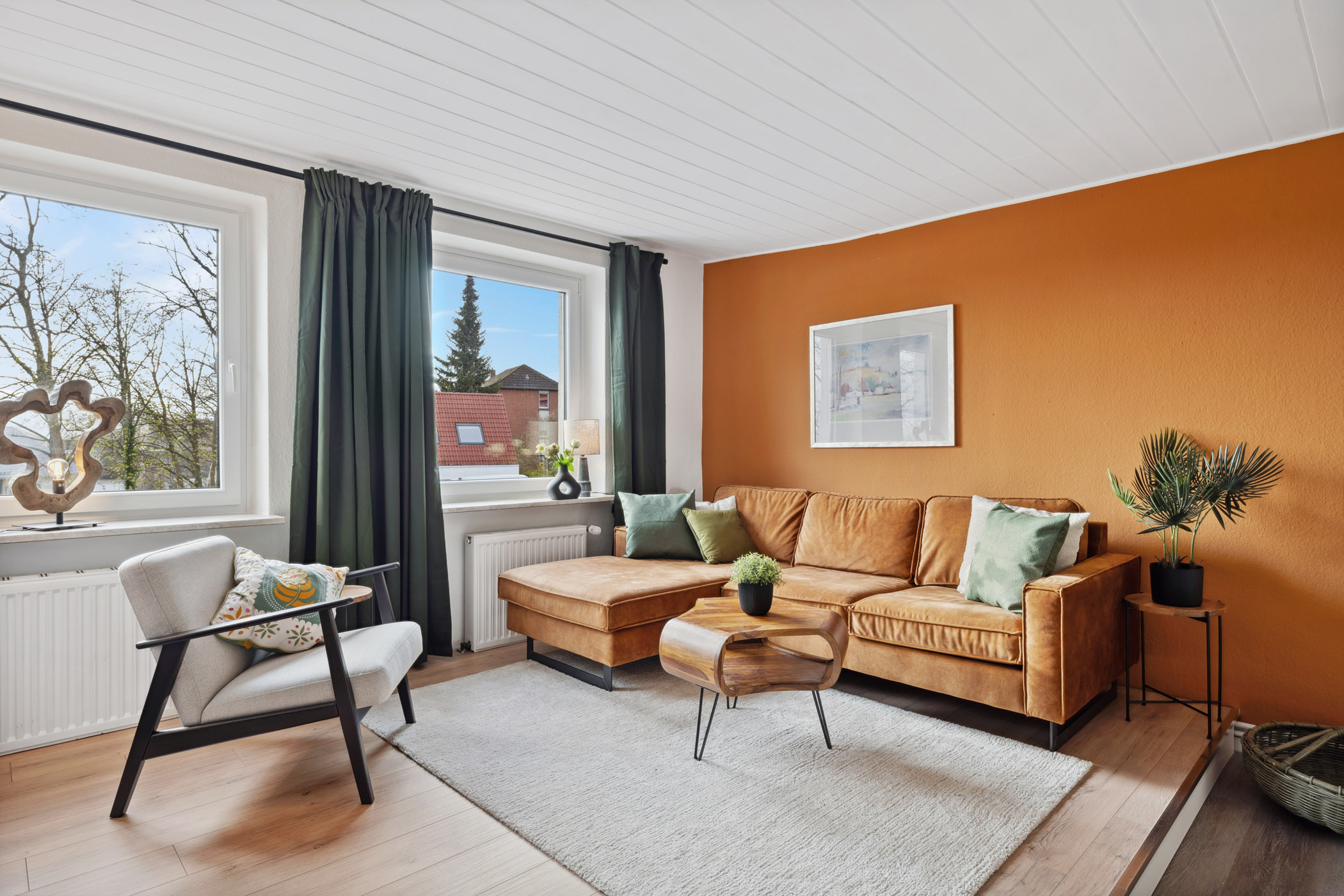 Wohnzimmer der Ferienwohnung Sperling mit Ecksofa und Blick ins Grüne