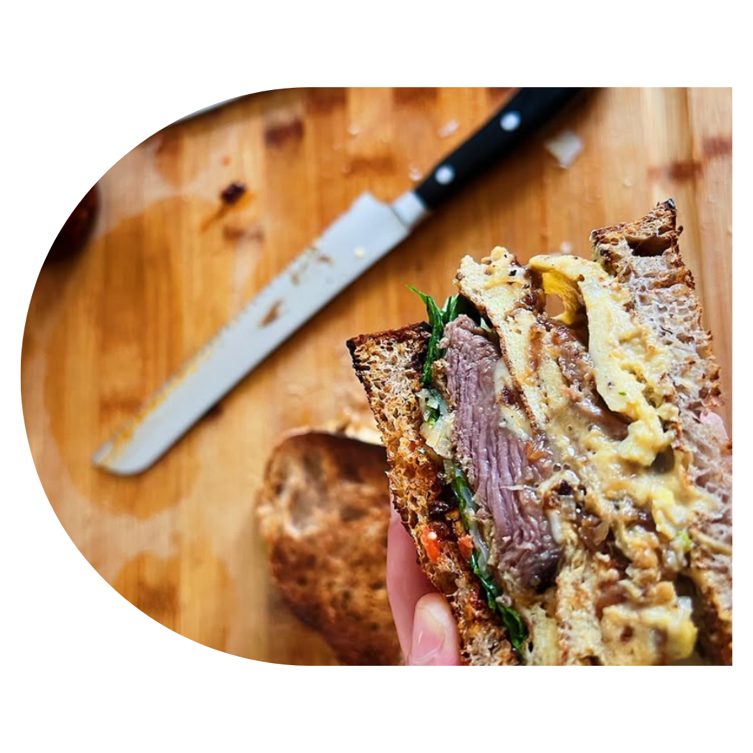 Positive young multiracial friends eating fast food and drinking beer in outdoor cafe