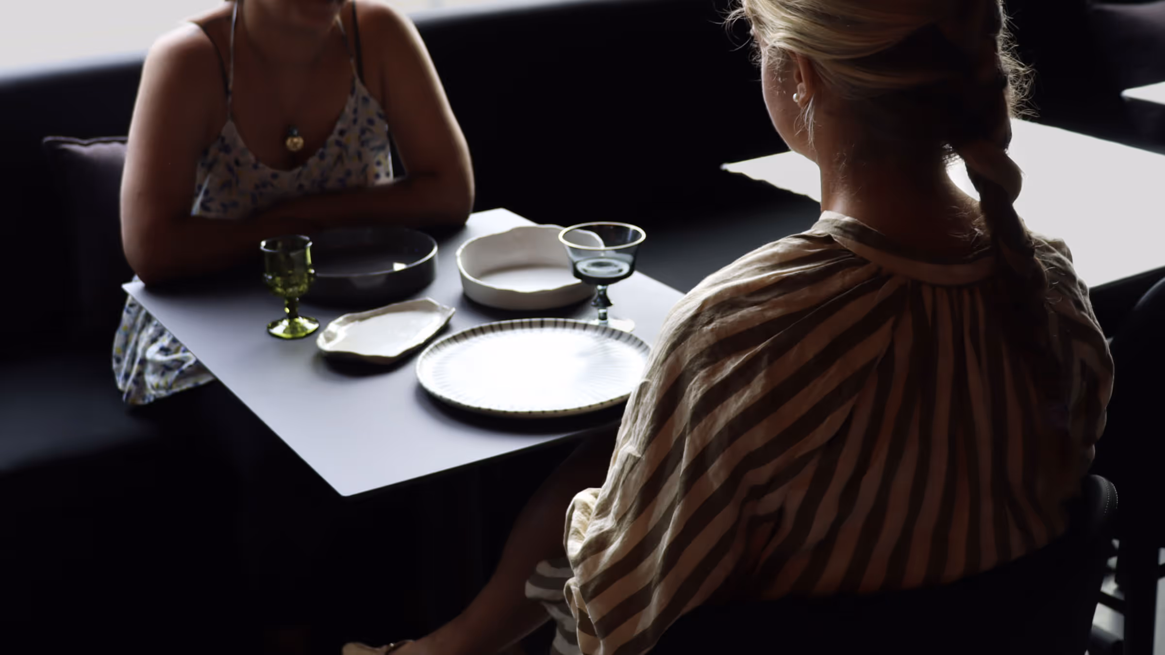 Two women at a table with unique place settings