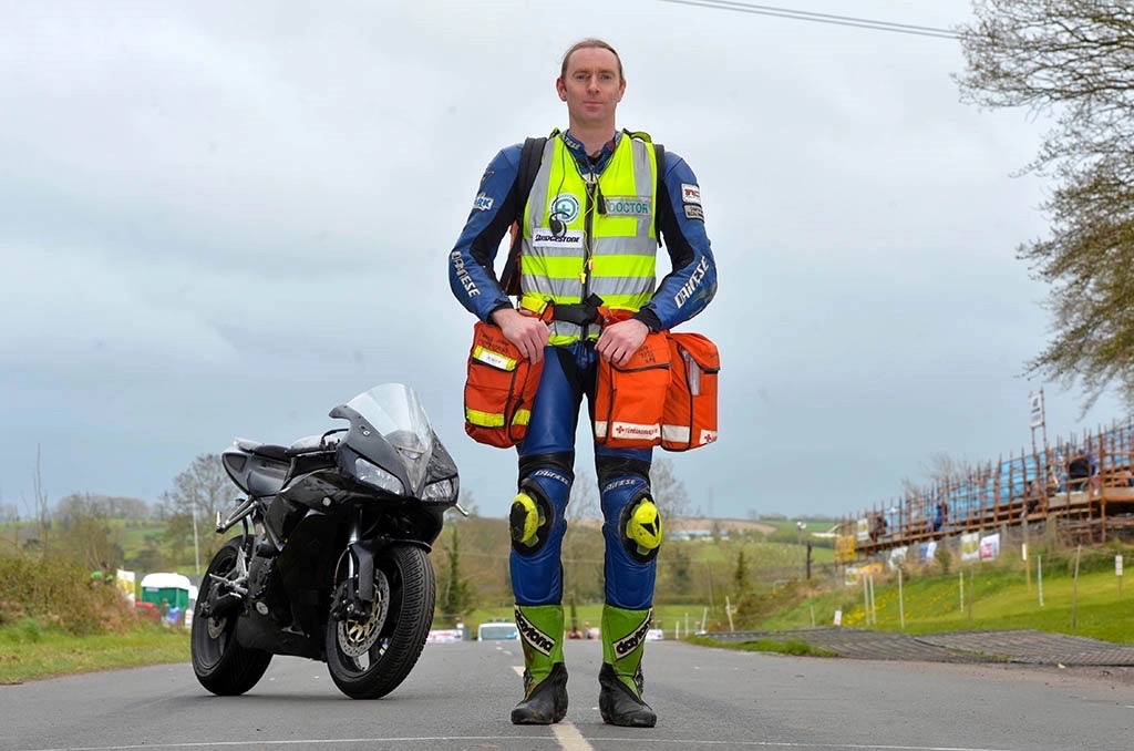 John avec sa moto en arrière plan