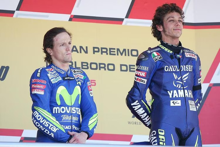 un podium qui illustre bien la confrontation entre rossi et gibernau avec les expressions fermées des pilotes