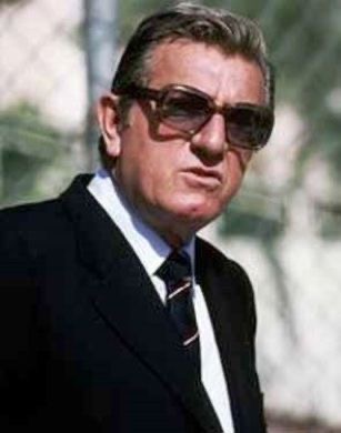 Portrait de Jean-Marie Balestre en costume sombre et lunettes teintées, symbole du pouvoir de la FISA au milieu des années 80.