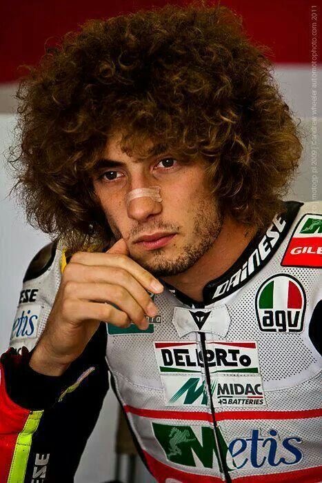 Portrait concentré de Marco Simoncelli dans le box avant un départ de course.