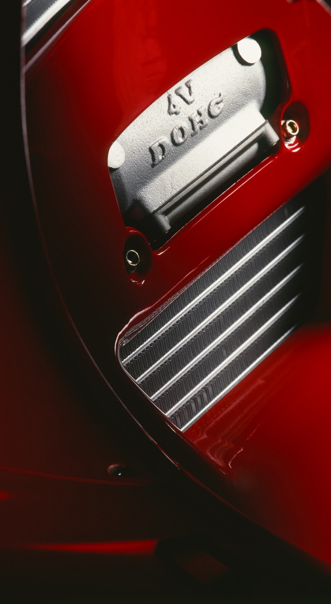 Détail du carénage rouge et de l’inscription “4V Desmo” sur le moteur de la Ducati 916, symbole du soin apporté à chaque pièce