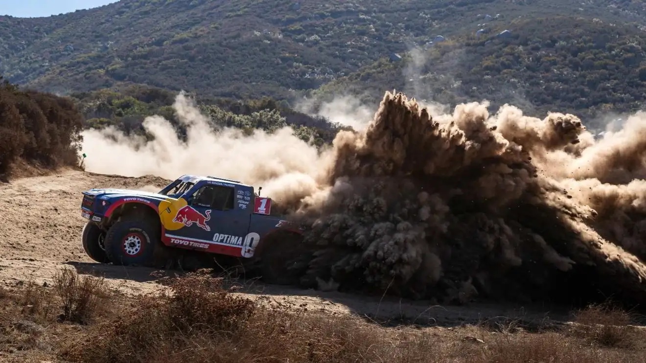 une image d'archive de la baja 1000 avec un 4x4 buggy redbull dans les dunes
