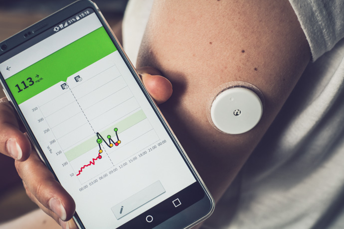 Hand holding a bottle of Zobo Jamaica soda with pink foam at the top.