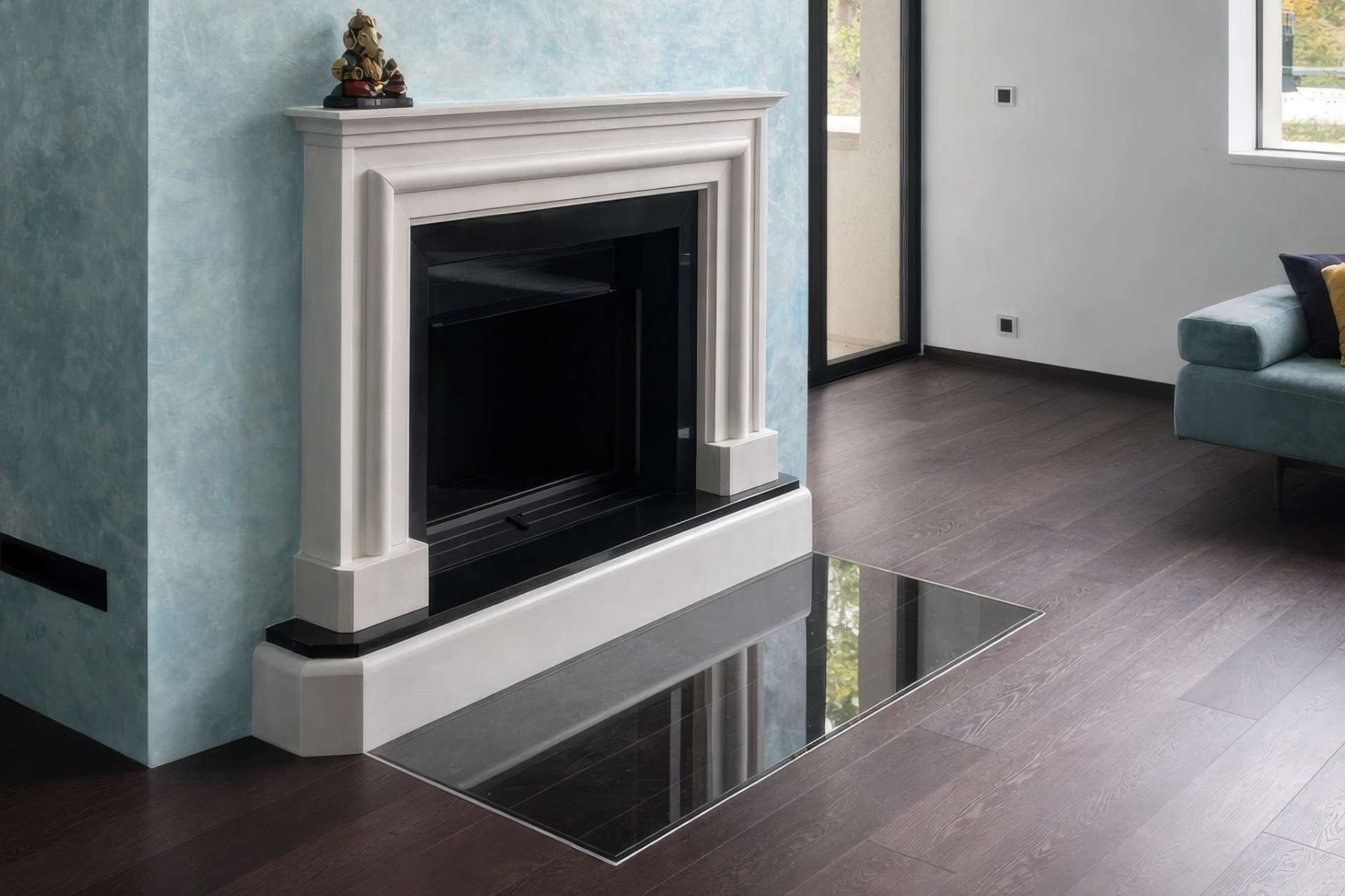 Klasický krbový portál se stupňovitým profilem a černým podstavcem na dřevěné podlaze, Kamenosochařství Hála Hořice.