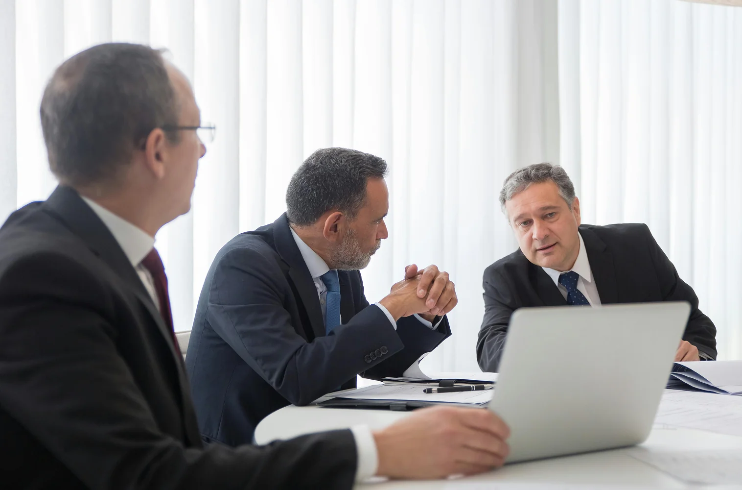 Three executives discussing how they can hit their targets after hiring Alpha Story