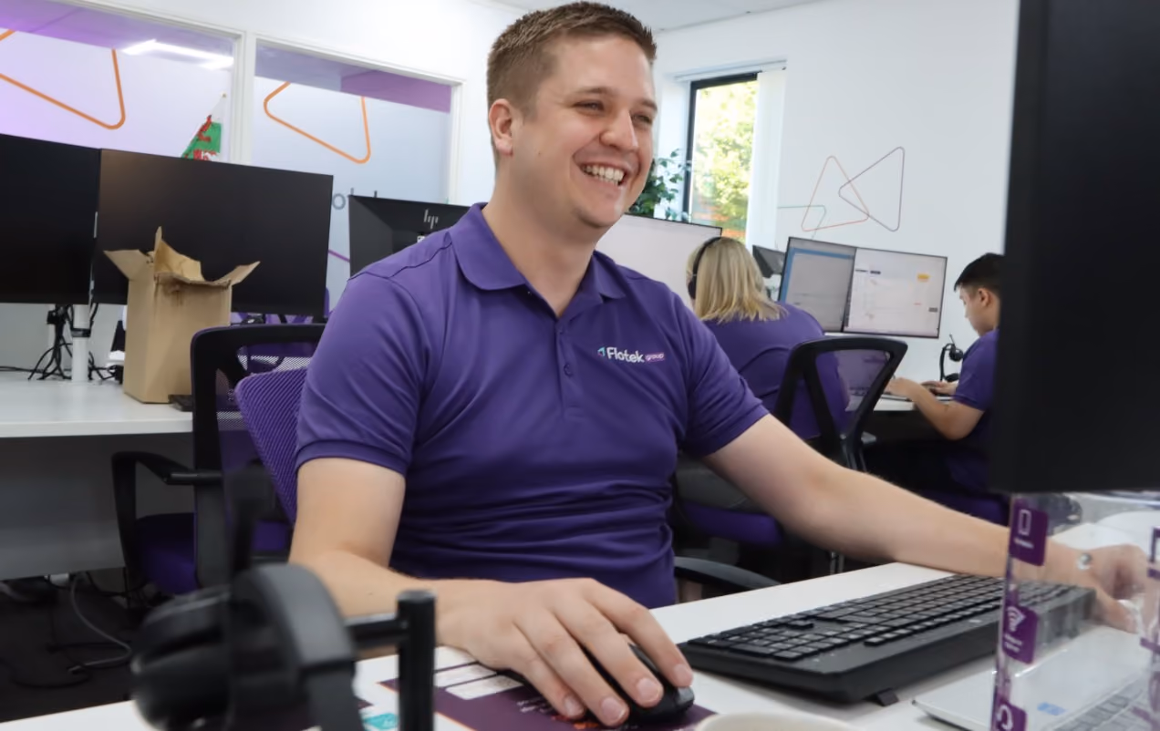 Flotek support engineer smiling at his desk, ready to help with your enquiry