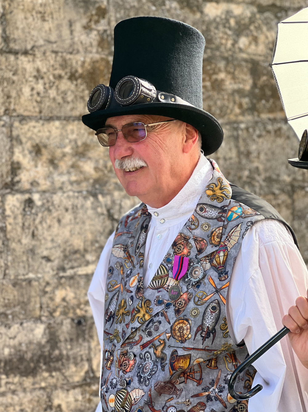 A smart steampunk man wearing a top hat and a colourful waistcoat
