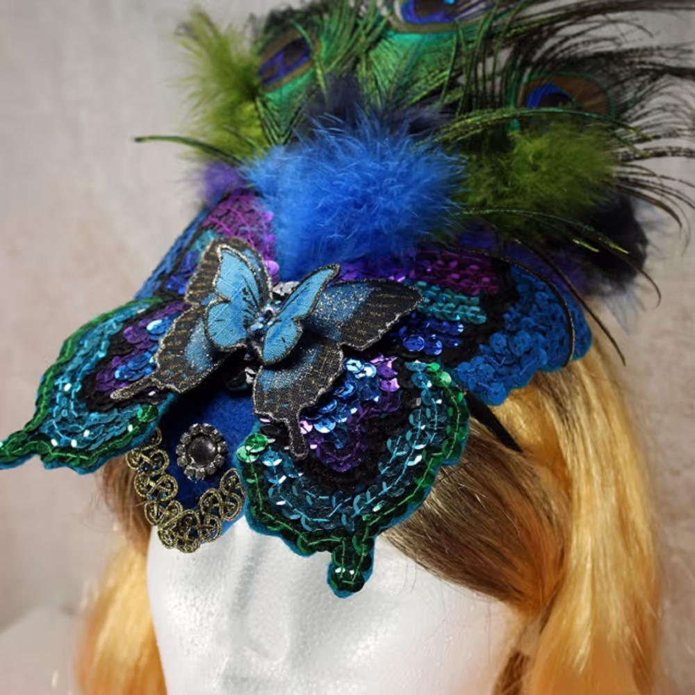A ladies fascinator decorated with a sequin butterfly and peacock feathers