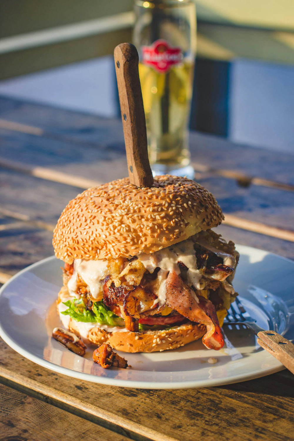 A burger on a plate and a glass of beer