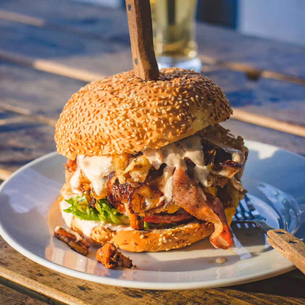 A burger on a plate and a glass of beer