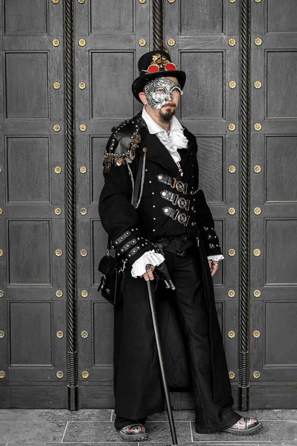 A man wearing a black steampunk costume
