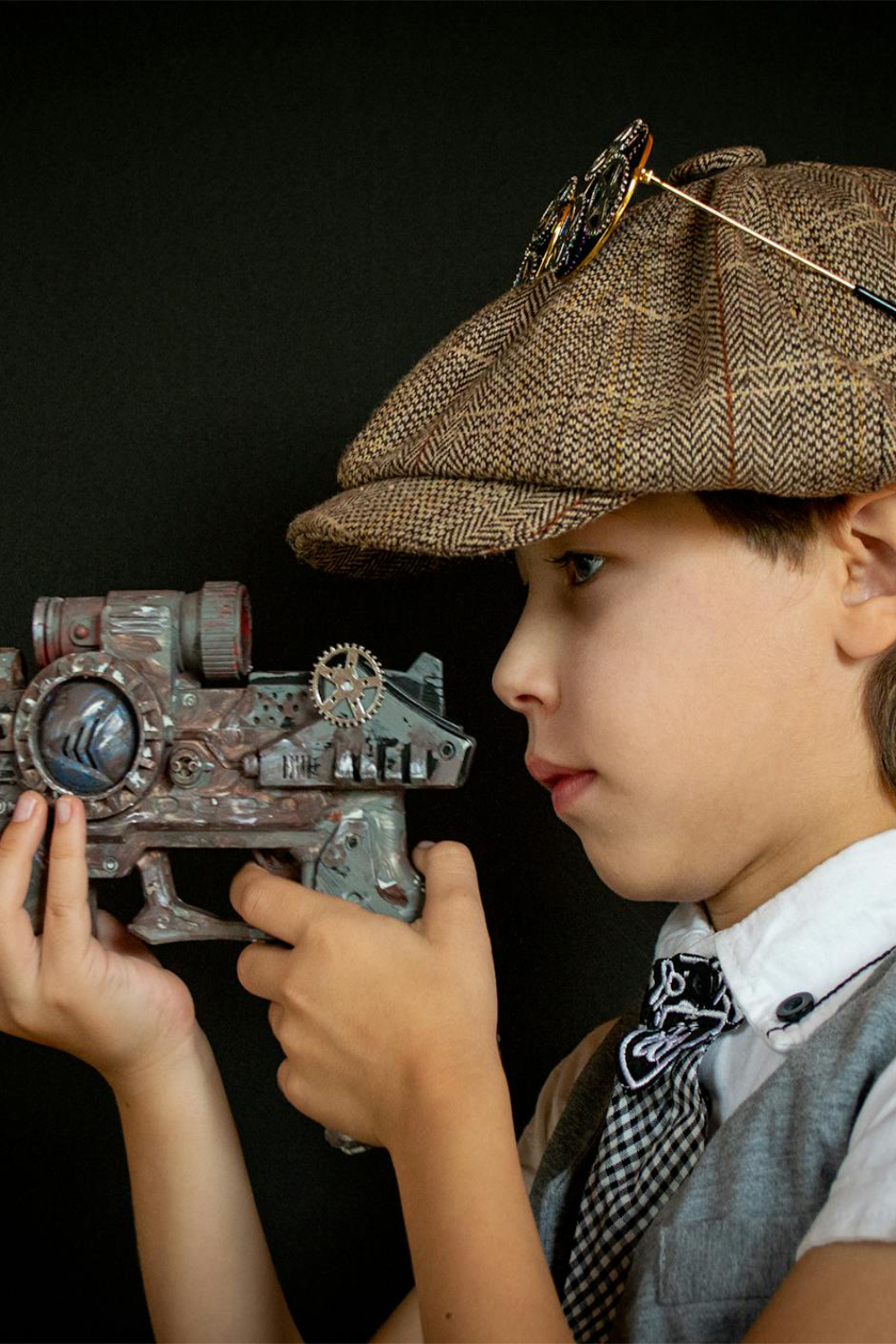 A child in a Victorian steampunk costume with a toy ray gun