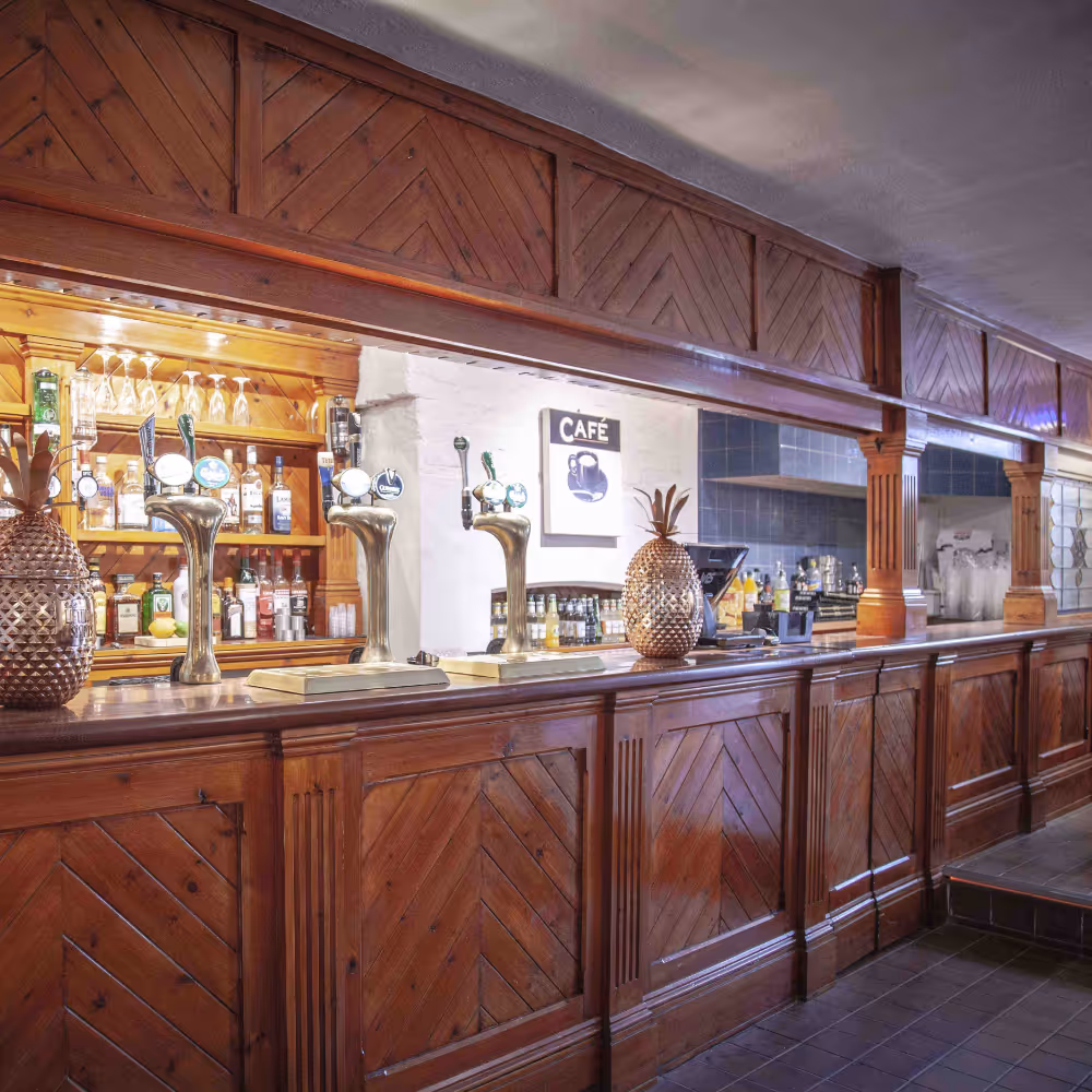 A cosy cellar bar with traditional wood panelling.