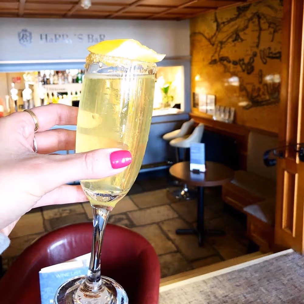Someone holding a glass of champagne in a hotel bar.